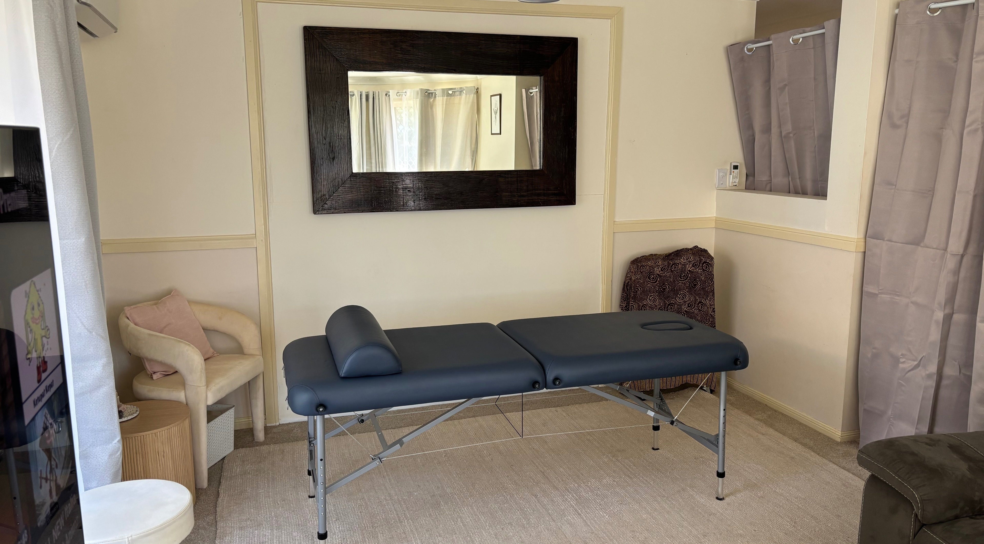 Relaxing treatment room at Muscle Recovery, Murrumba Downs, Queensland, AU with massage table and seating.