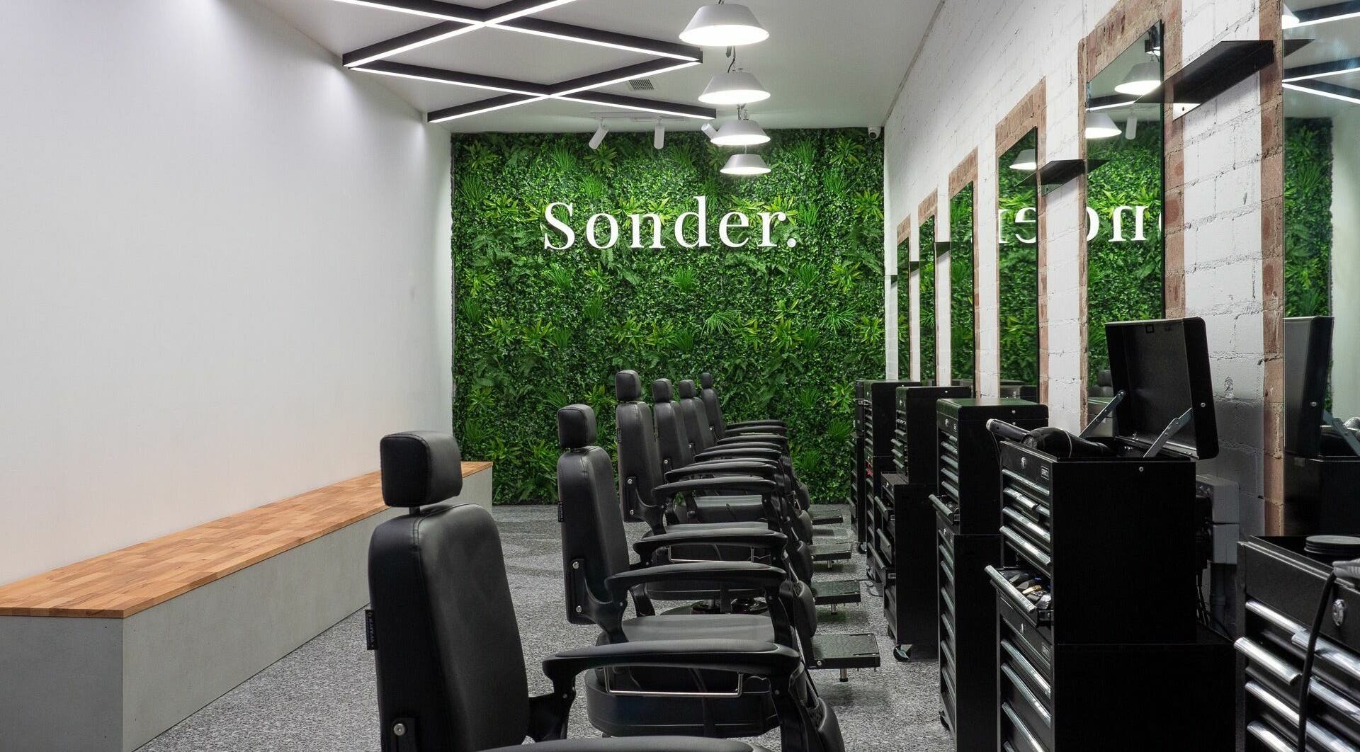 Elegant interior of Sonder Mens | Neutral Bay, featuring black chairs and green wall, located in Neutral Bay, New South Wales, AU.