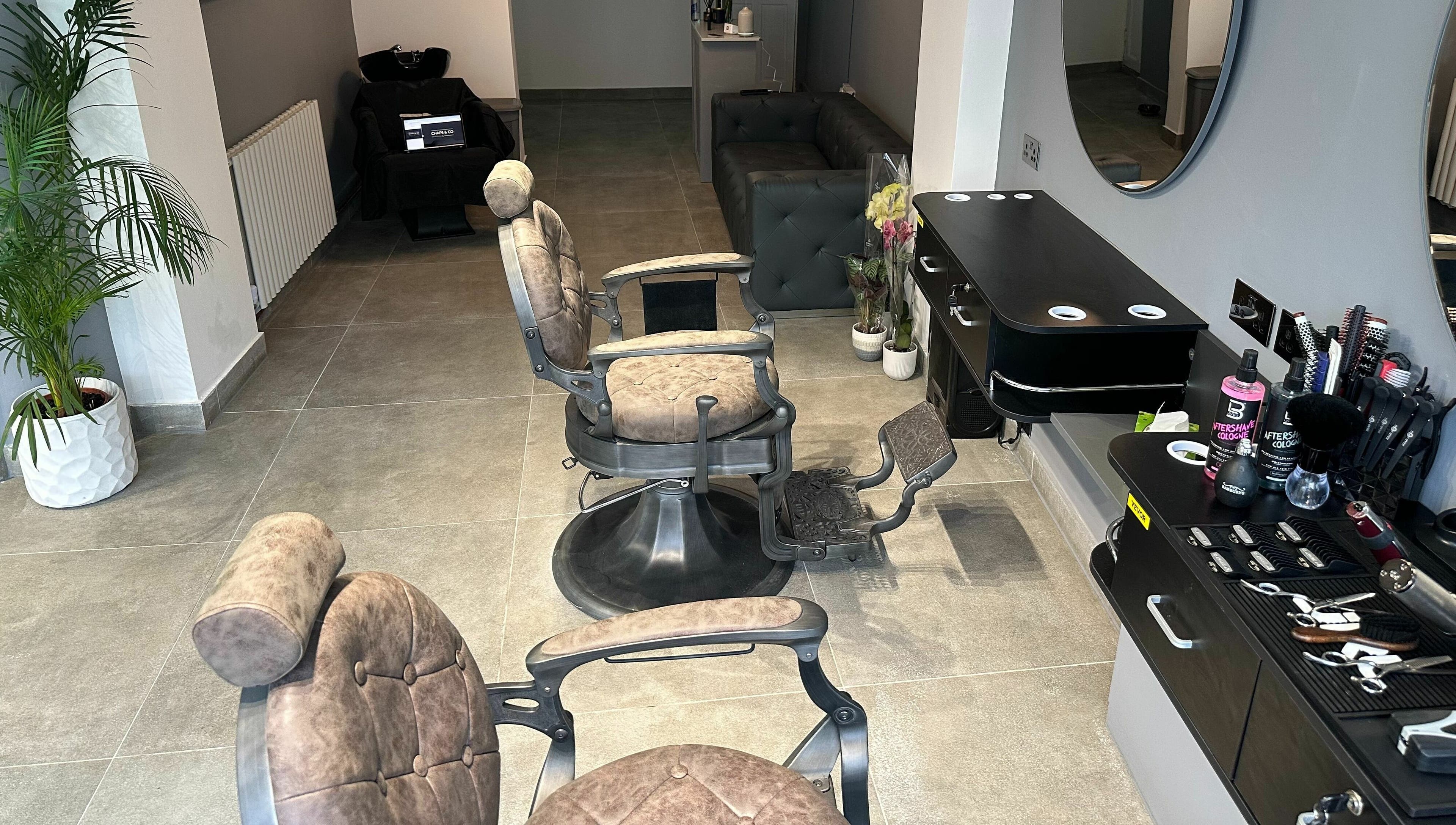 Barber chairs and styling area at Chaps Cut, Barnet, England, GB showcasing modern interior design.