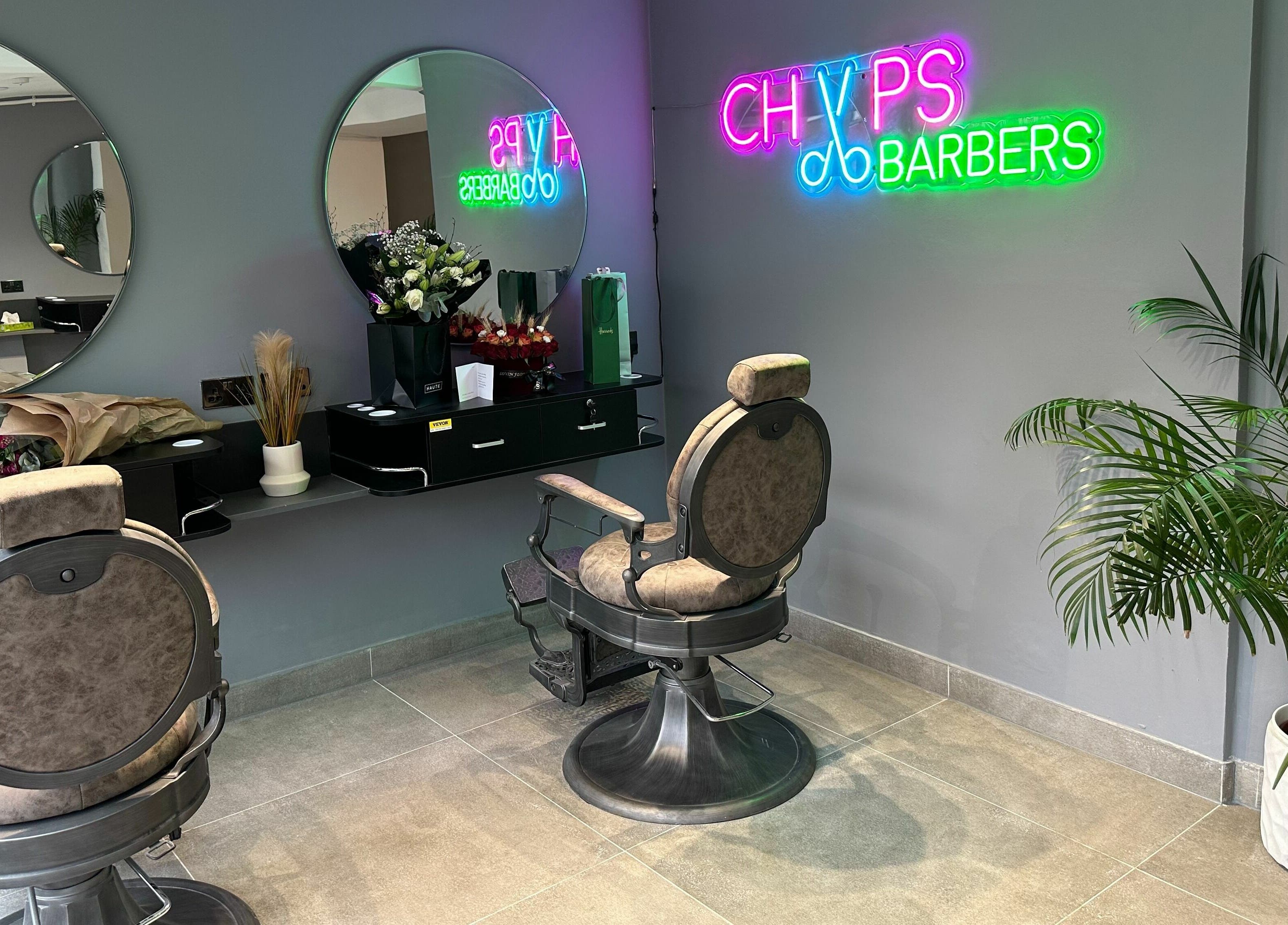 Modern barber chair and neon sign at Chaps Cut in Barnet, England, GB.