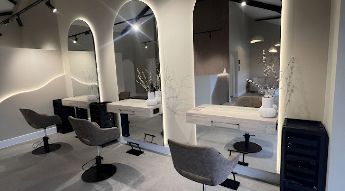 Modern salon interior at SY Glamour & Glow at Hair by Nina & Co, Shrewsbury, England, GB with stylish chairs and mirrors.