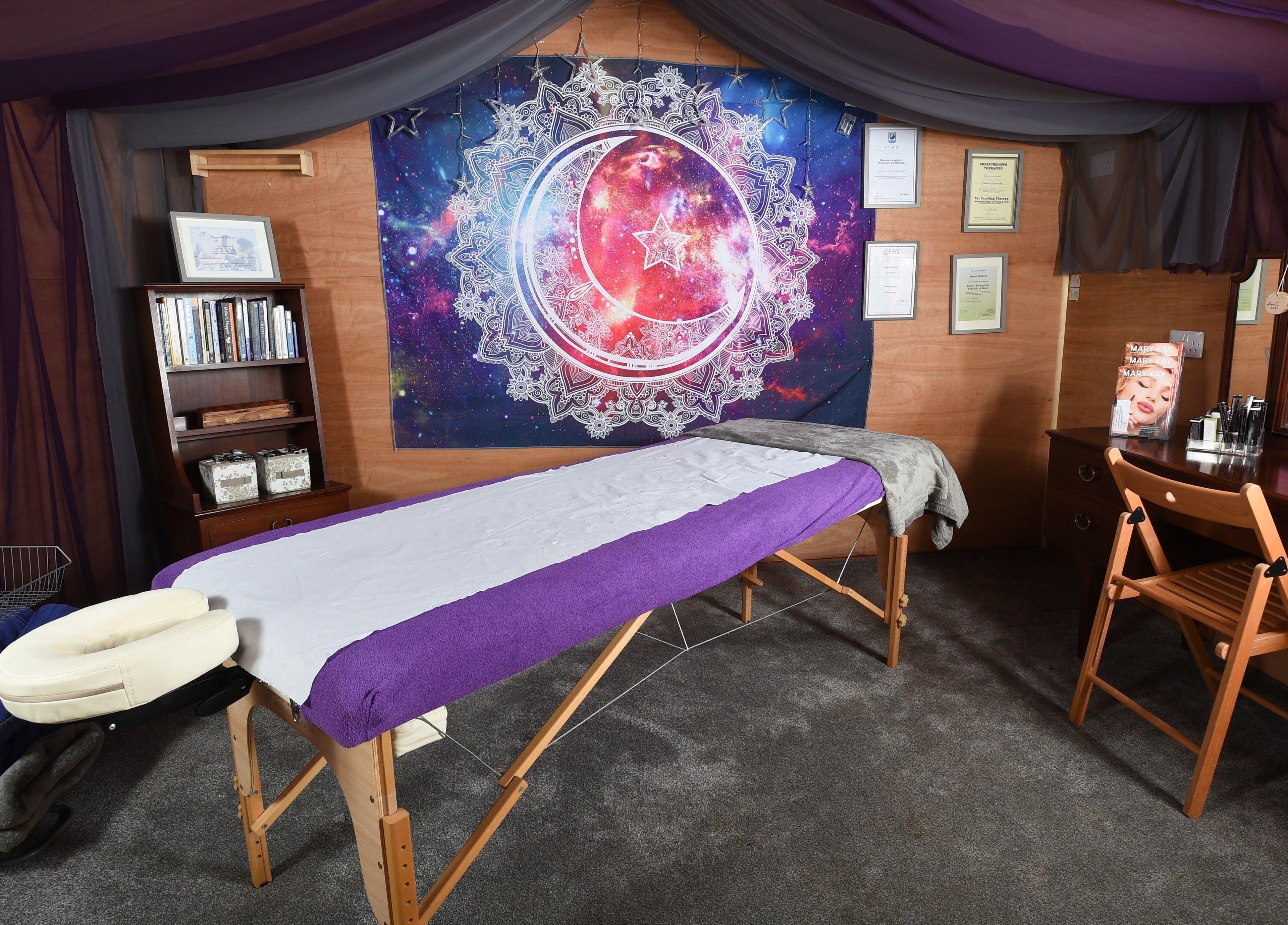 Relaxing therapy room at Trinity Wellness, Stokenchurch, England, GB with cosmic decor and massage table.