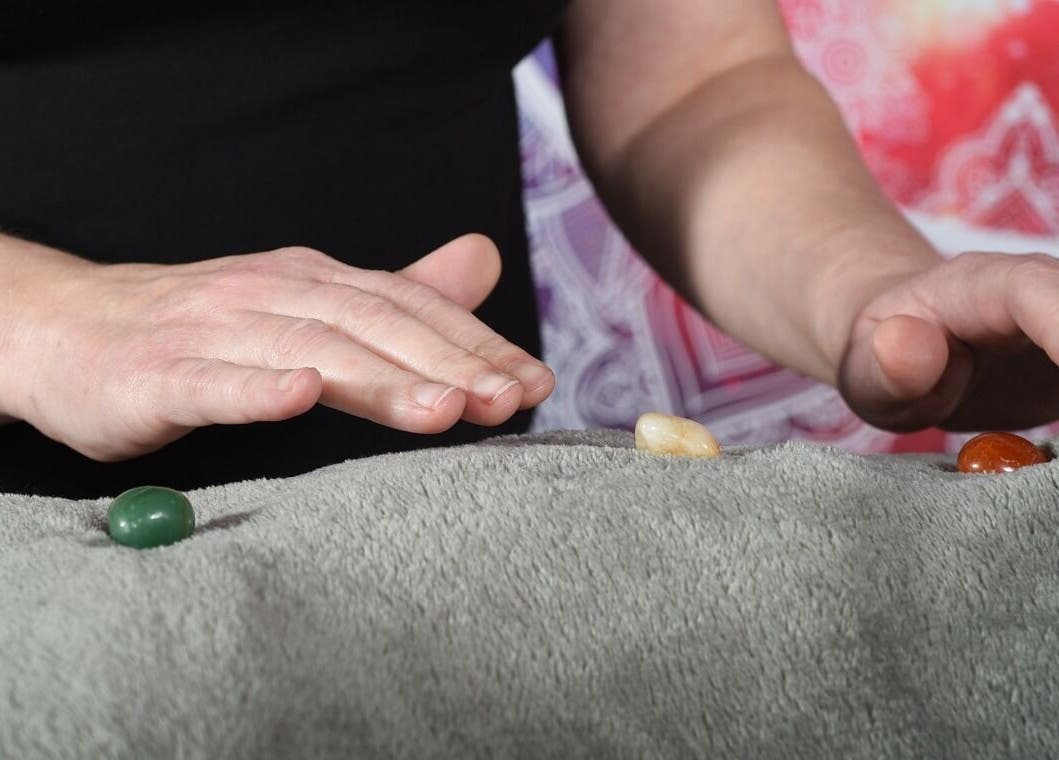 Hands hovering over healing stones at Trinity Wellness, Stokenchurch, England, GB.
