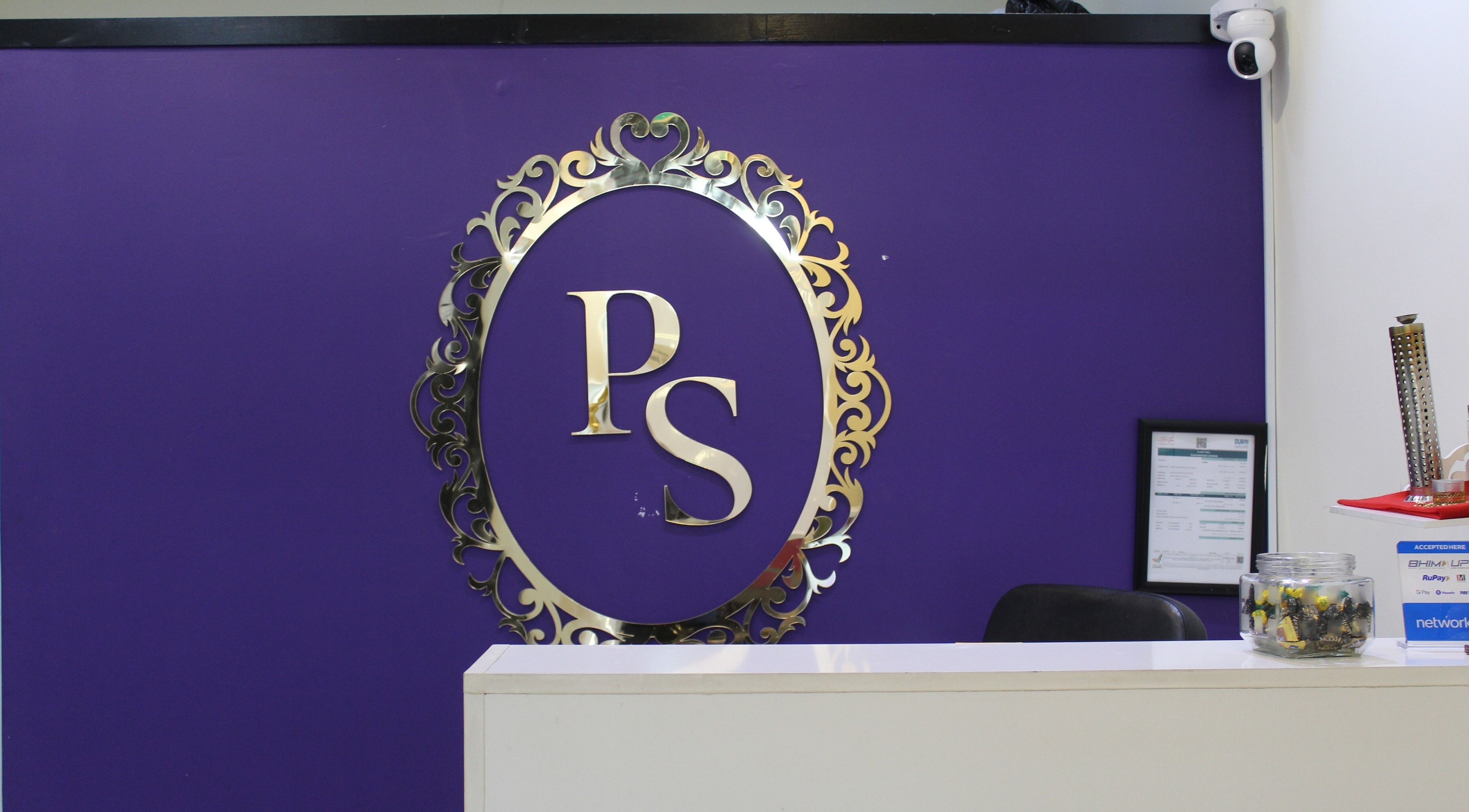 Reception area of Posh Signature Salon in Dubai, AE, featuring a purple wall with stylish logo.