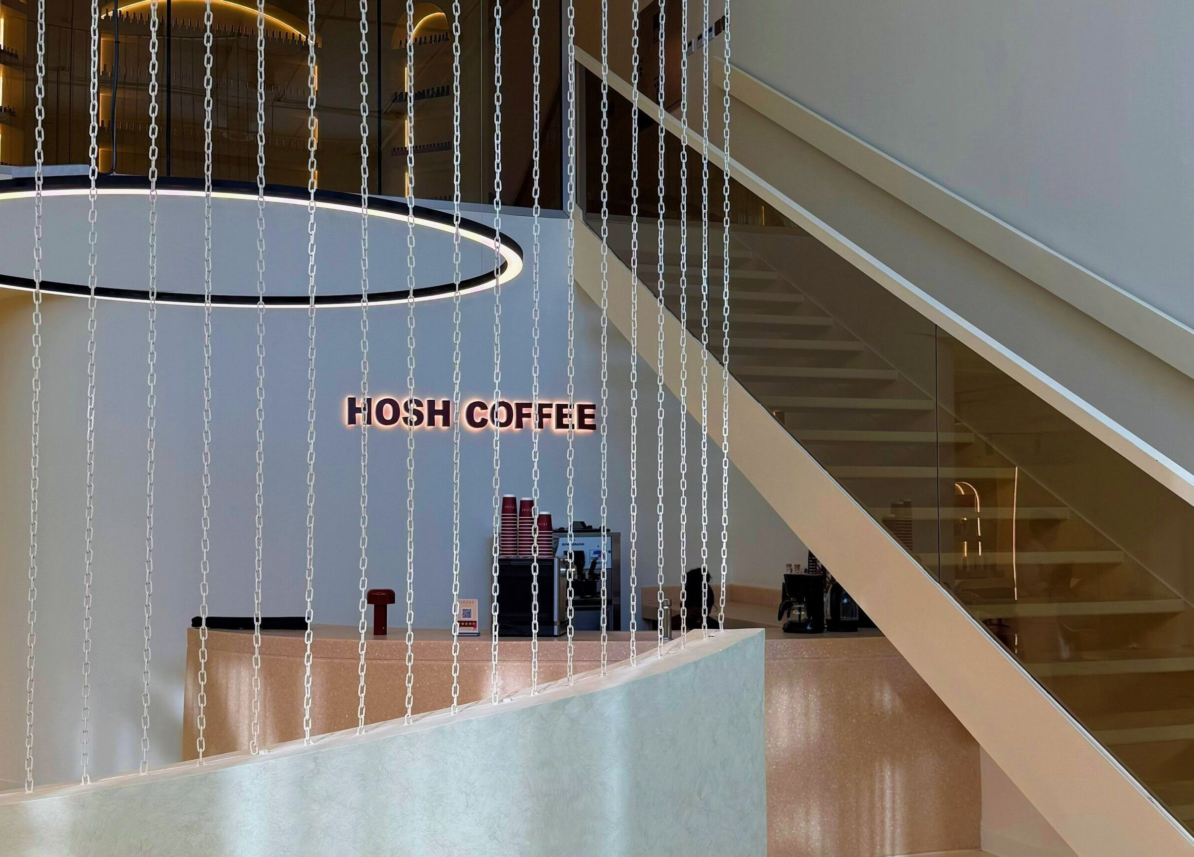 Elegant coffee area at HOSH - House Of Shroug Salon, Riyadh, SA with modern design and ambient lighting.