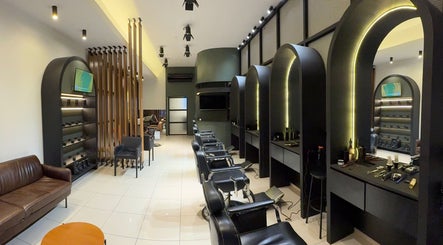 Interior moderno da KÓDEN - Barbearia e Visagismo em Jundiaí, São Paulo, BR, com cadeiras e iluminação estilosa.