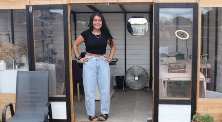 Woman smiling at LP Extensions, Fordingbridge, England, GB, stylish salon studio entrance with decor.