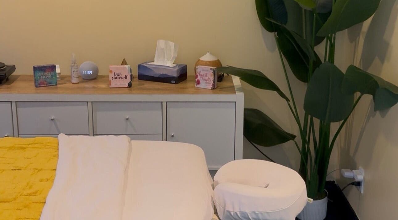 Relaxing massage table setup at HoliSoi / HoliSelf in Montréal, Québec, CA, with calming decor and vibrant plant.