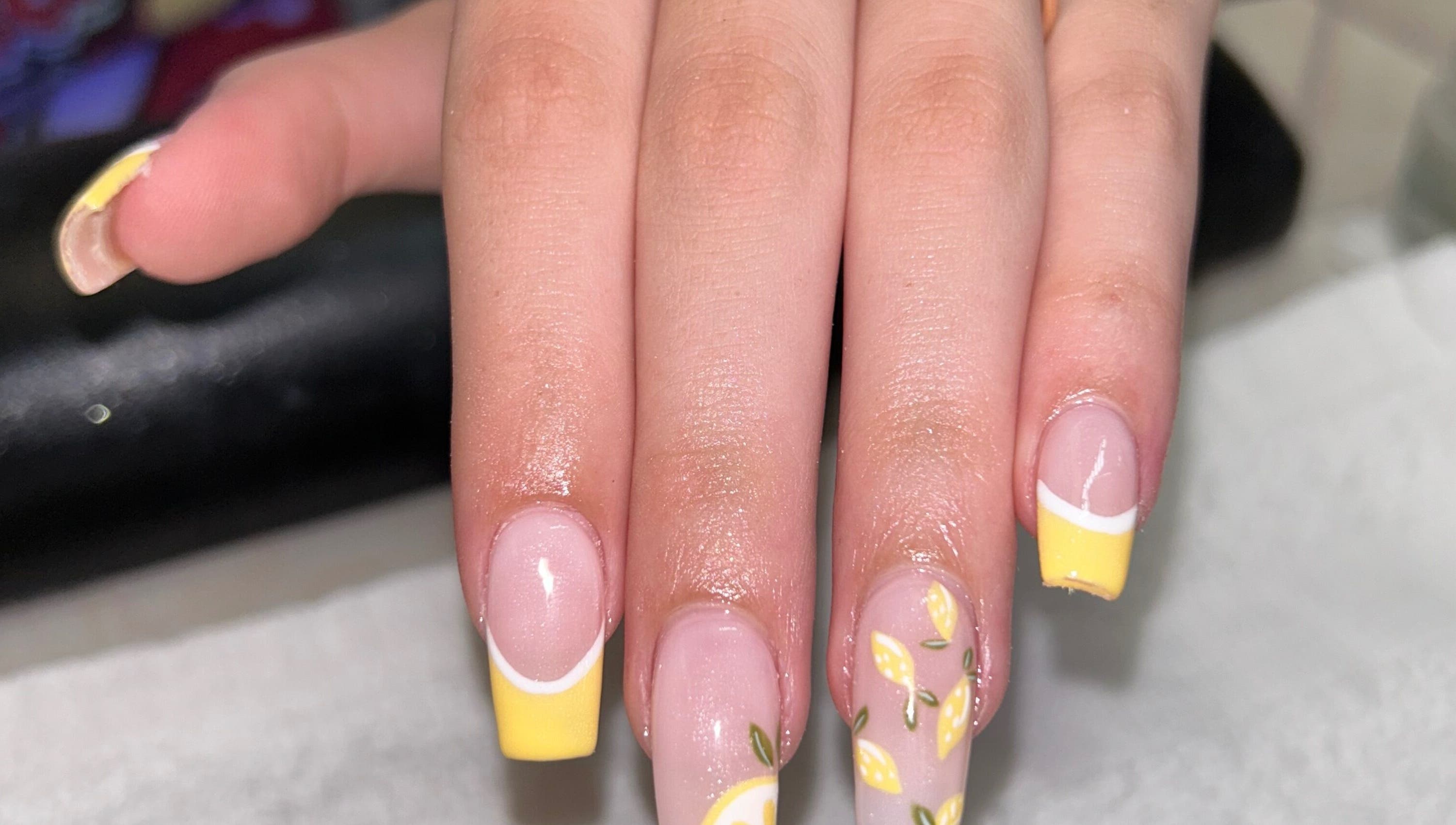 Lemon-themed nail art at The Lacquer Bar, Chatham, Ontario, CA showcasing vibrant yellow tips.