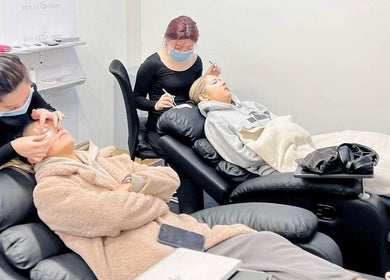 Clients receiving eyelash extensions at Holylashes North Melbourne, Melbourne, Victoria, AU in relaxing chairs.