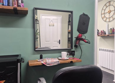 Beauty station inside The Green Lounge, Haughley, England, GB, with a mirror, hair tools, and products.