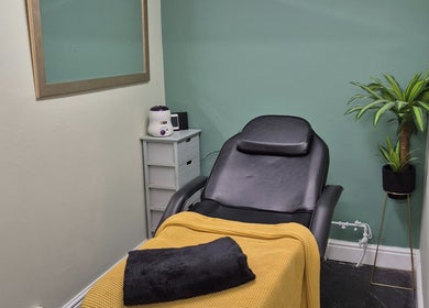 Relaxing spa room at The Green Lounge, Haughley, England, GB with a cozy chair and a potted plant.