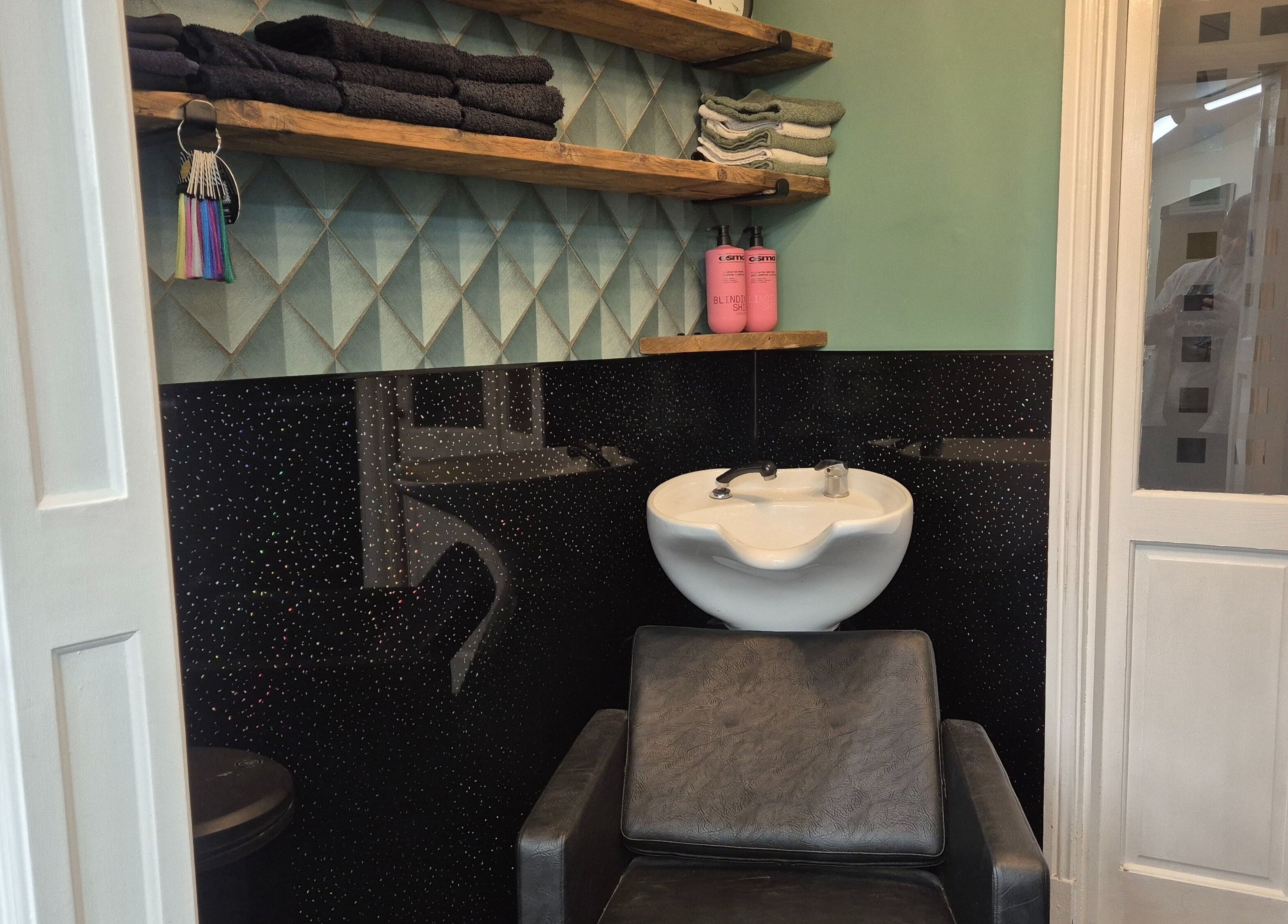 Modern salon wash station at The Green Lounge, Haughley, England, GB. Features sleek design and plush seating.