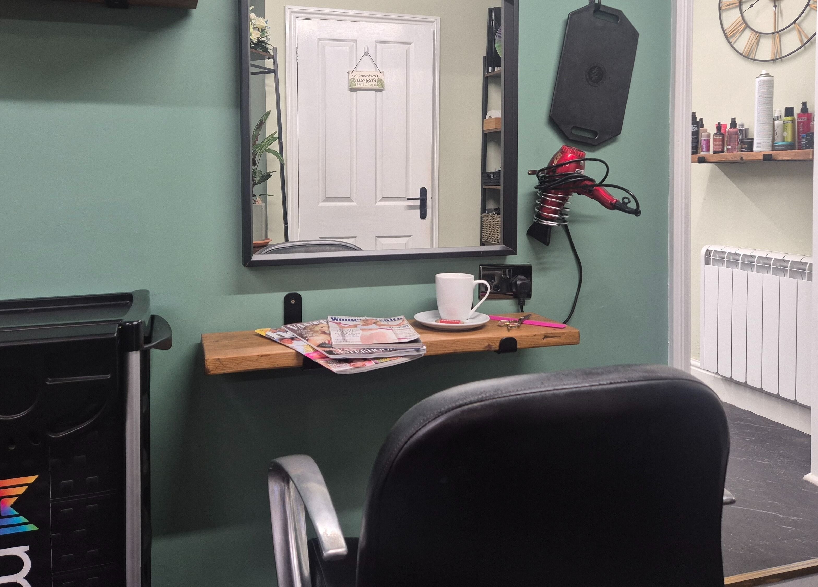 Cozy salon corner at The Green Lounge, Haughley, England, GB with a mirror, chair, and styling tools.