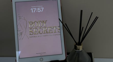 Tablet displaying Body Secrets - West London logo with aromatic diffuser, London, England, GB.