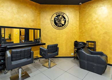 Modern interior of Exotic Indian Salon Richmond, New South Wales, AU with sleek black chairs against a vibrant yellow wall.