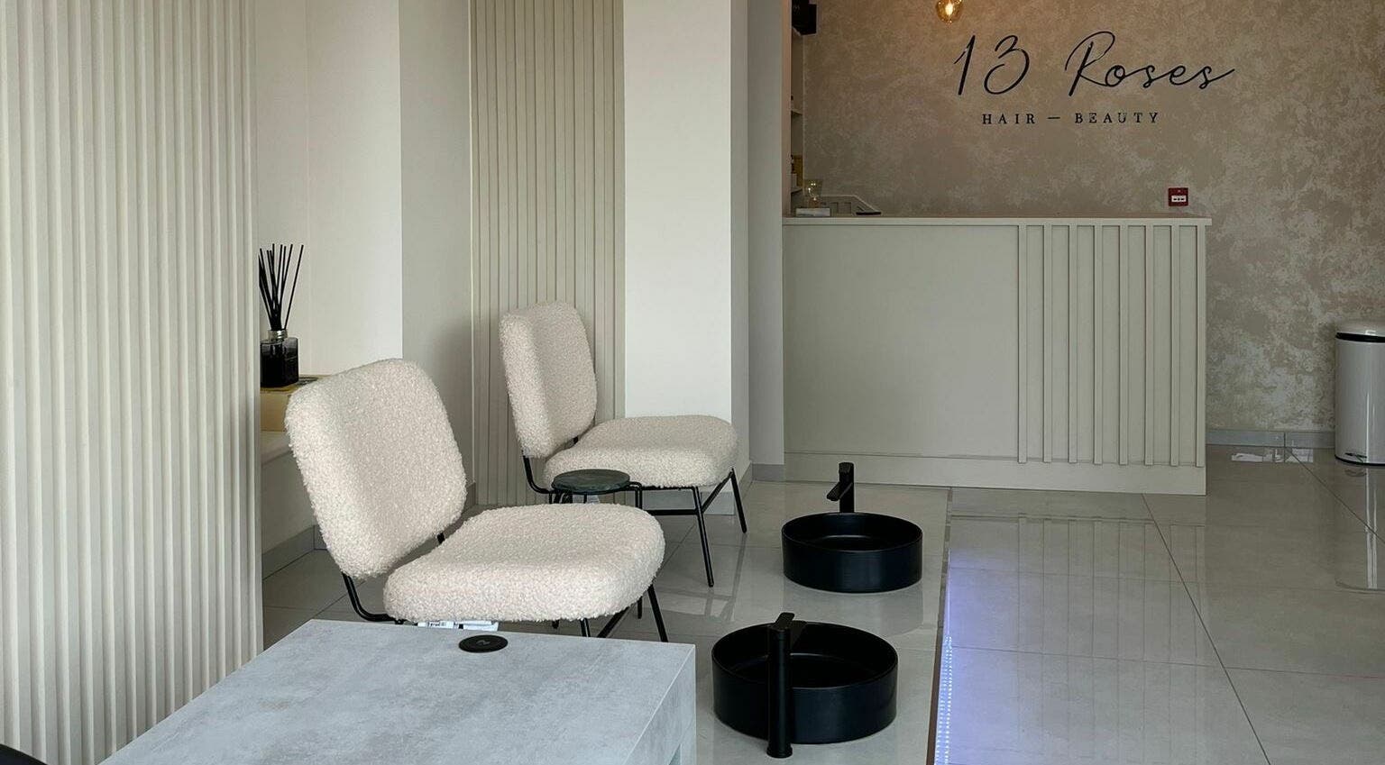 Modern salon seating area at 13 Roses, London, England, GB, featuring elegant decor and comfortable chairs.