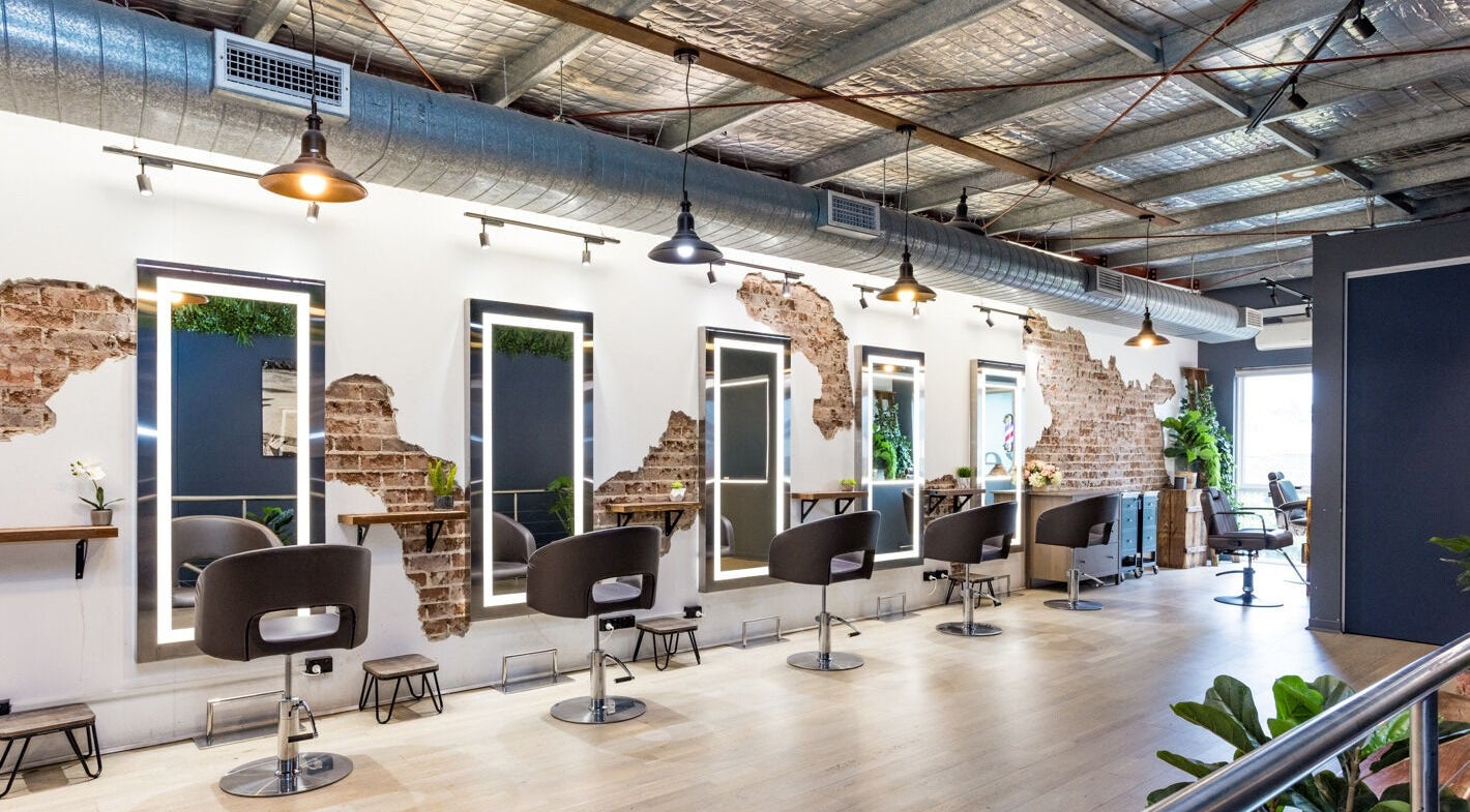 Modern salon interior at Evoke Hair Darling Park in Sydney, New South Wales, AU with stylish chairs and mirrors.