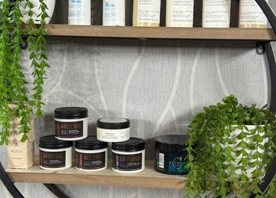 Stylish shelf at Shiren Hair & Beauty in Regina, Saskatchewan, CA showcasing luxury beauty products and lush greenery.