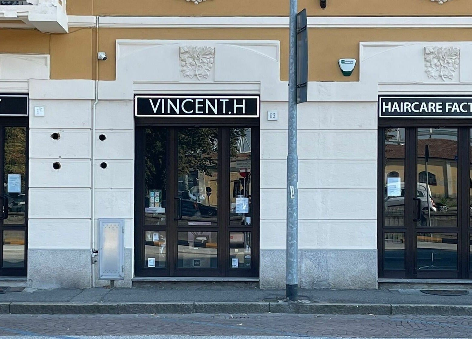 Ingresso di VINCENT.H Haircare Factory a Cremona, Lombardia, IT con eleganti vetrate scure.