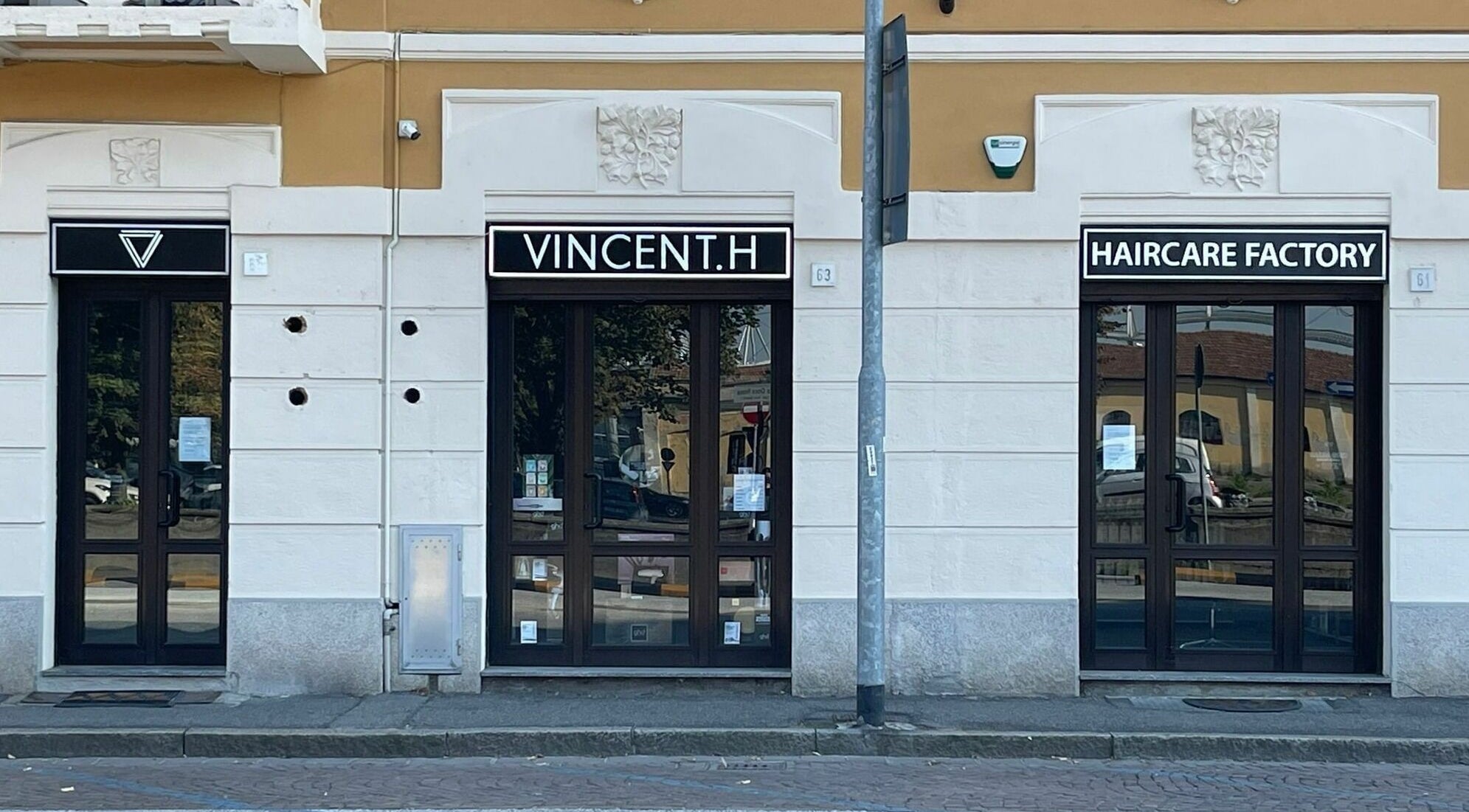 Ingresso di VINCENT.H Haircare Factory a Cremona, Lombardia, IT con eleganti vetrate scure.