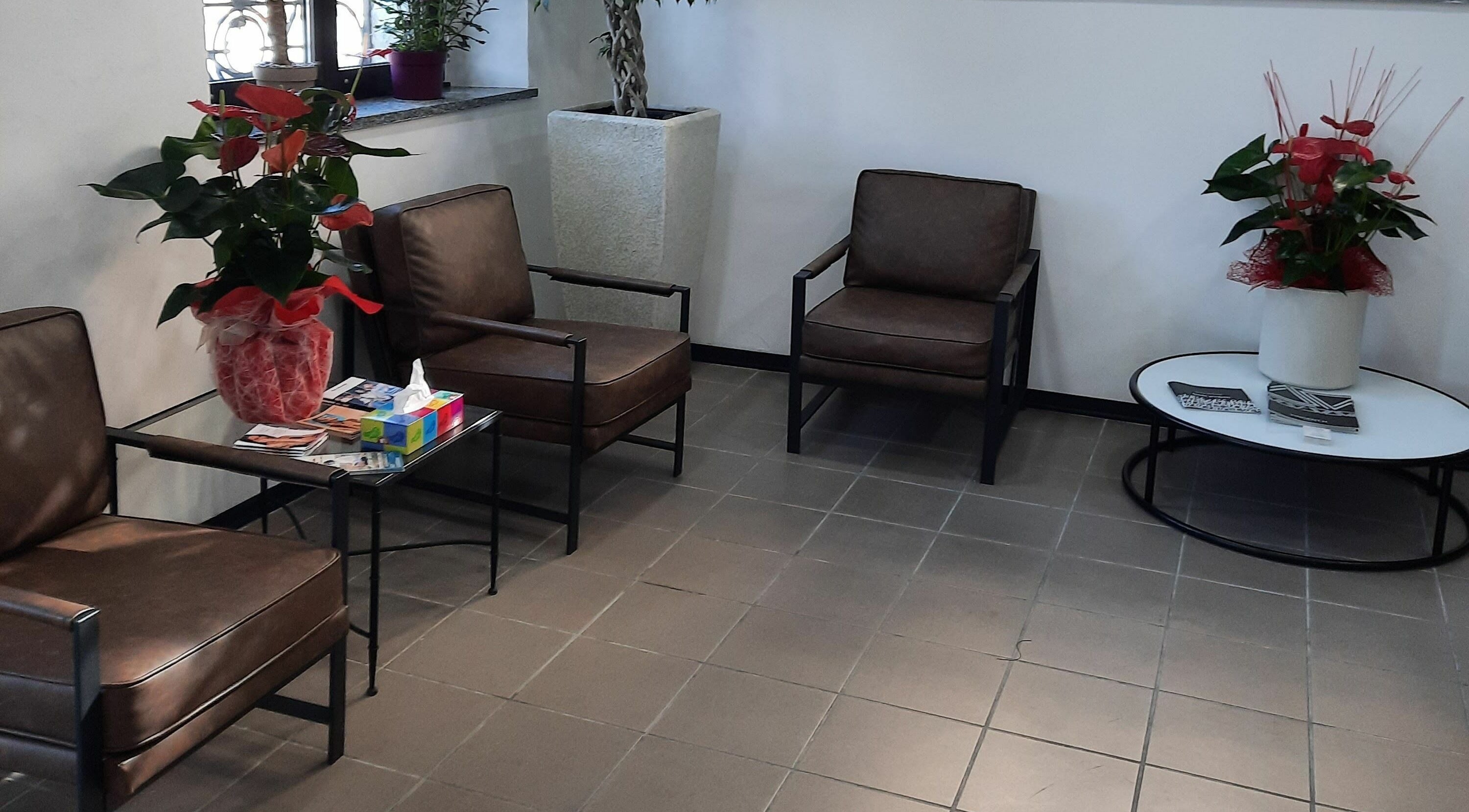 Area attesa con poltrone e piante presso VINCENT.H Haircare Factory, Cremona, Lombardia, IT.