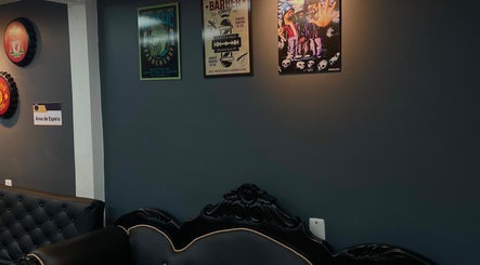 Sala de espera en Barberia Full HD, Bogotá, CUNDINAMARCA, CO, con sofás elegantes y carteles de barbería.