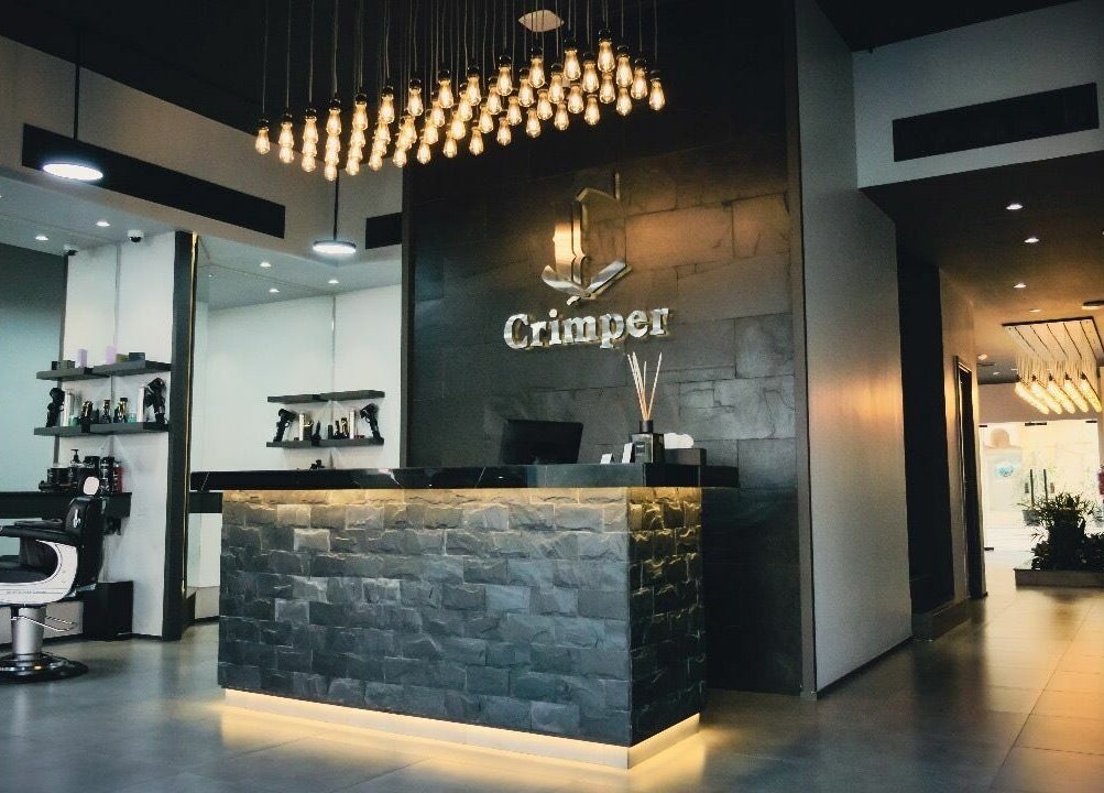 Reception area at Crimper Gents Salon and Spa in دبي, دبي, AE featuring chic modern decor and lighting.