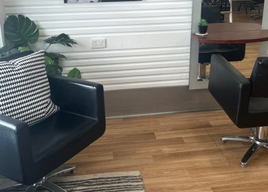 Elegant seating area at Kut Loose Hairdesign Robe, Robe, South Australia, AU, with modern black chairs.