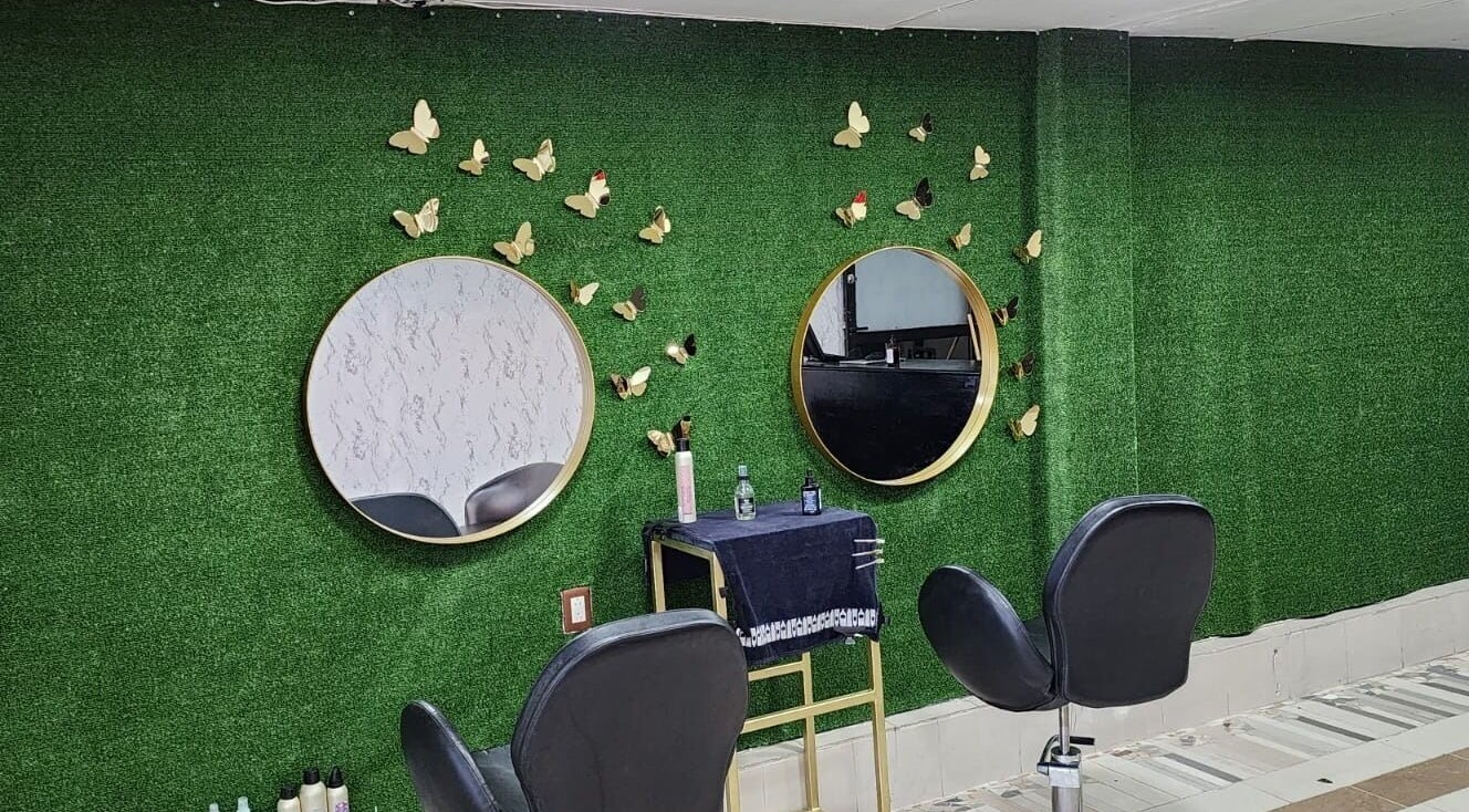 Interior estiloso de Gladys Alonso en Coatzacoalcos, Veracruz, MX con espejos circulares y sillas de salón.