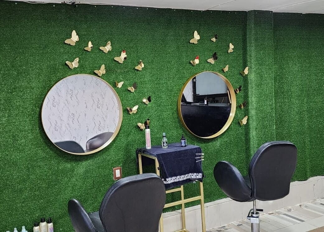 Interior moderno de Gladys Alonso en Coatzacoalcos, Veracruz, MX con espejos dorados y sillas negras.