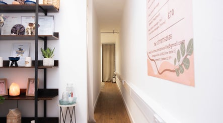 Calming hallway at Paul Sri, London, England, GB with decor and awards on display shelves.
