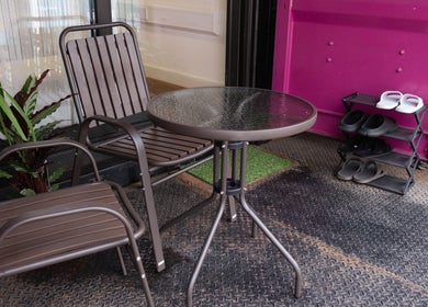 Cozy patio setting at Paul Sri in London, England, GB with chairs, table, and potted plants.