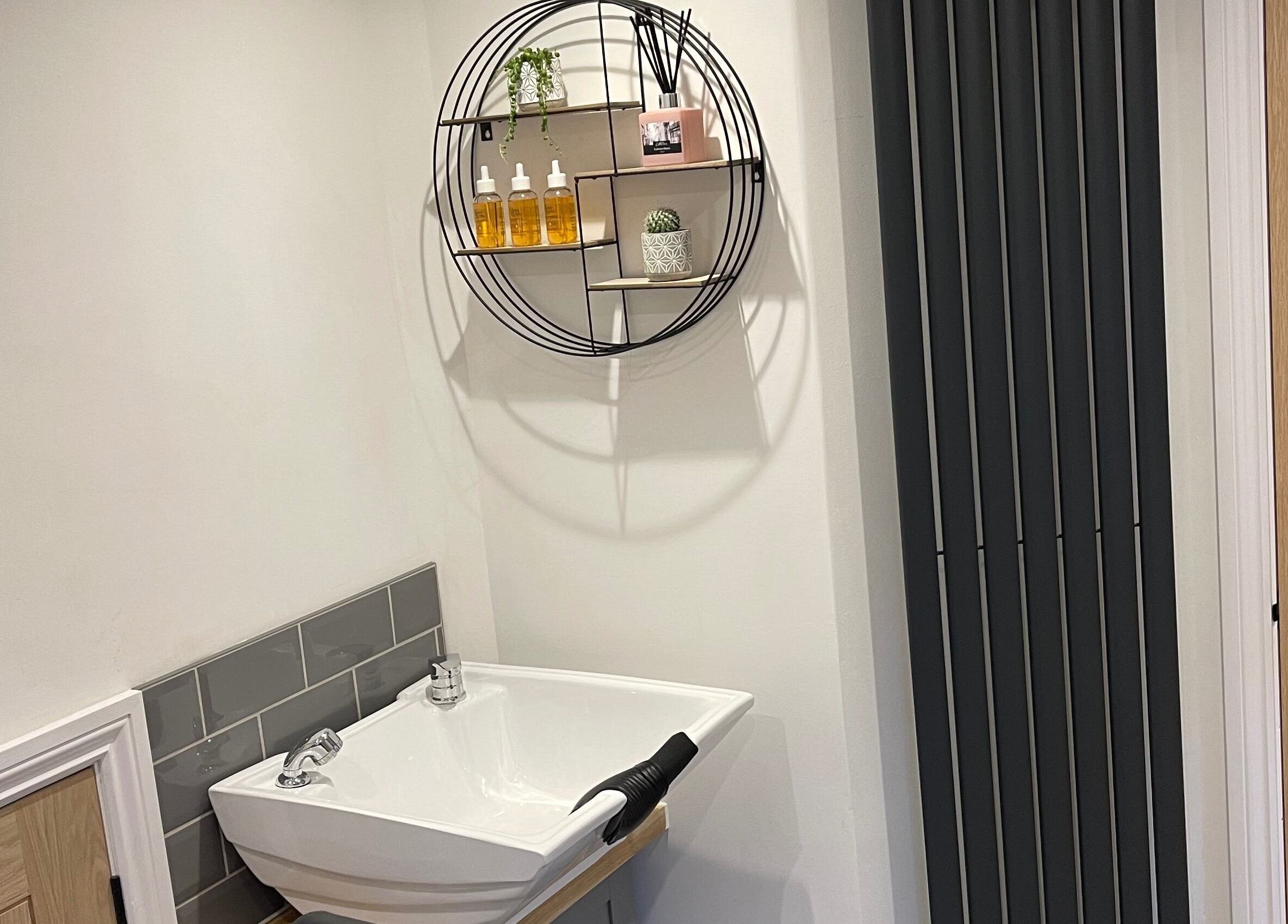 Modern salon sink with circular shelf at Natalie Mae Hair, Sturminster Newton, England, GB.