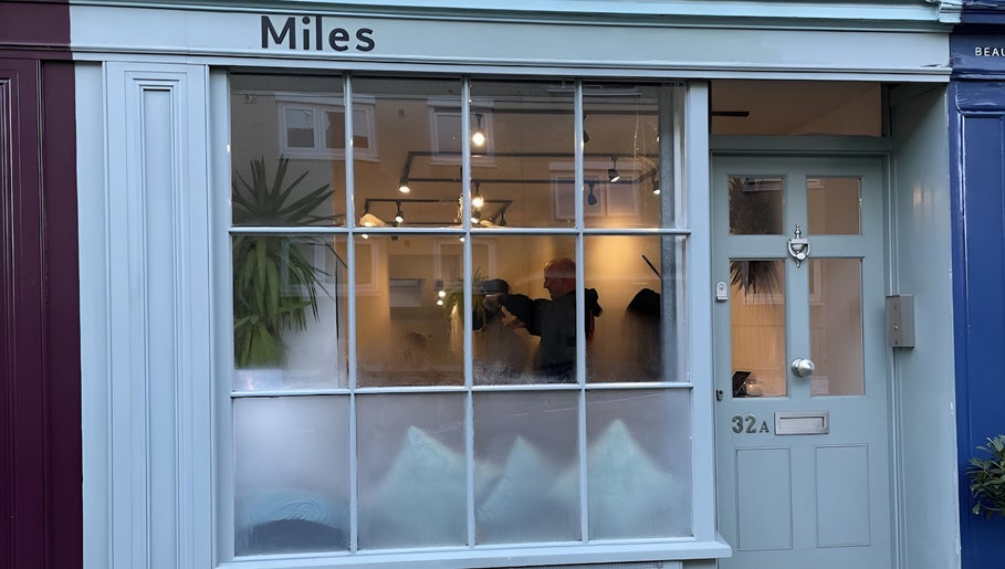 Exterior of Miles Rhodes Hair Stylist, Bath, England, GB, showing large windows and stylish entrance.