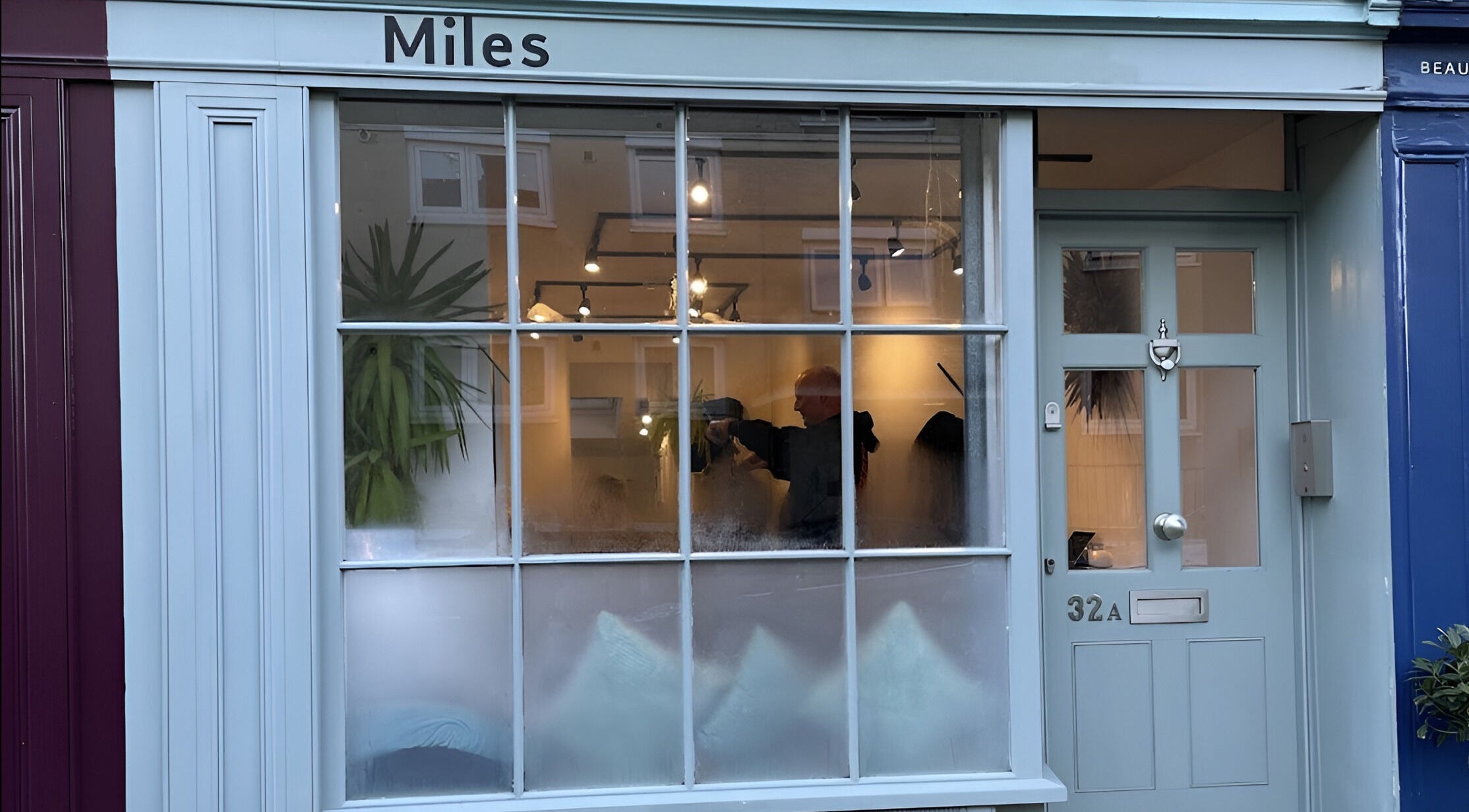 Exterior of Miles Rhodes Hair Stylist, Bath, England, GB, showing large windows and stylish entrance.