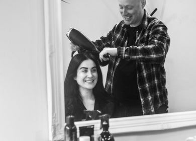 Hair stylist at Miles Rhodes Hair Stylist, Bath, England, GB, smiling with client in salon.