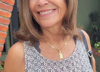 Smiling woman with light brown hair and floral top at Hair Care Center, Burbank, California, US.