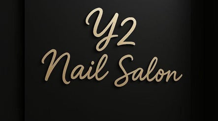 Elegant signage of Y2 Nail Salon in Ontario, California, US with gold lettering on a dark background.