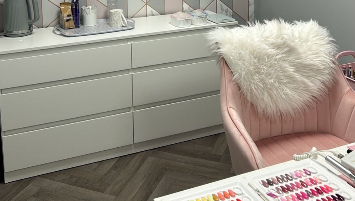 CLC Nails in Telford, England, GB features a chic nail station with soft pink chair and nail polish samples.