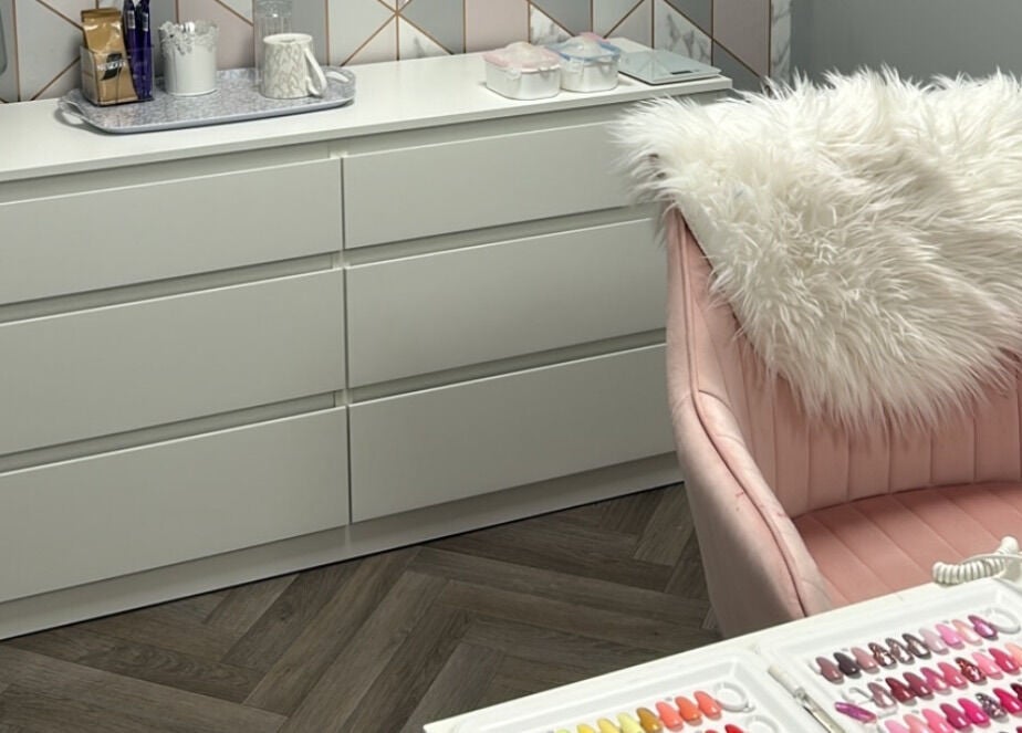 CLC Nails in Telford, England, GB features a chic nail station with soft pink chair and nail polish samples.