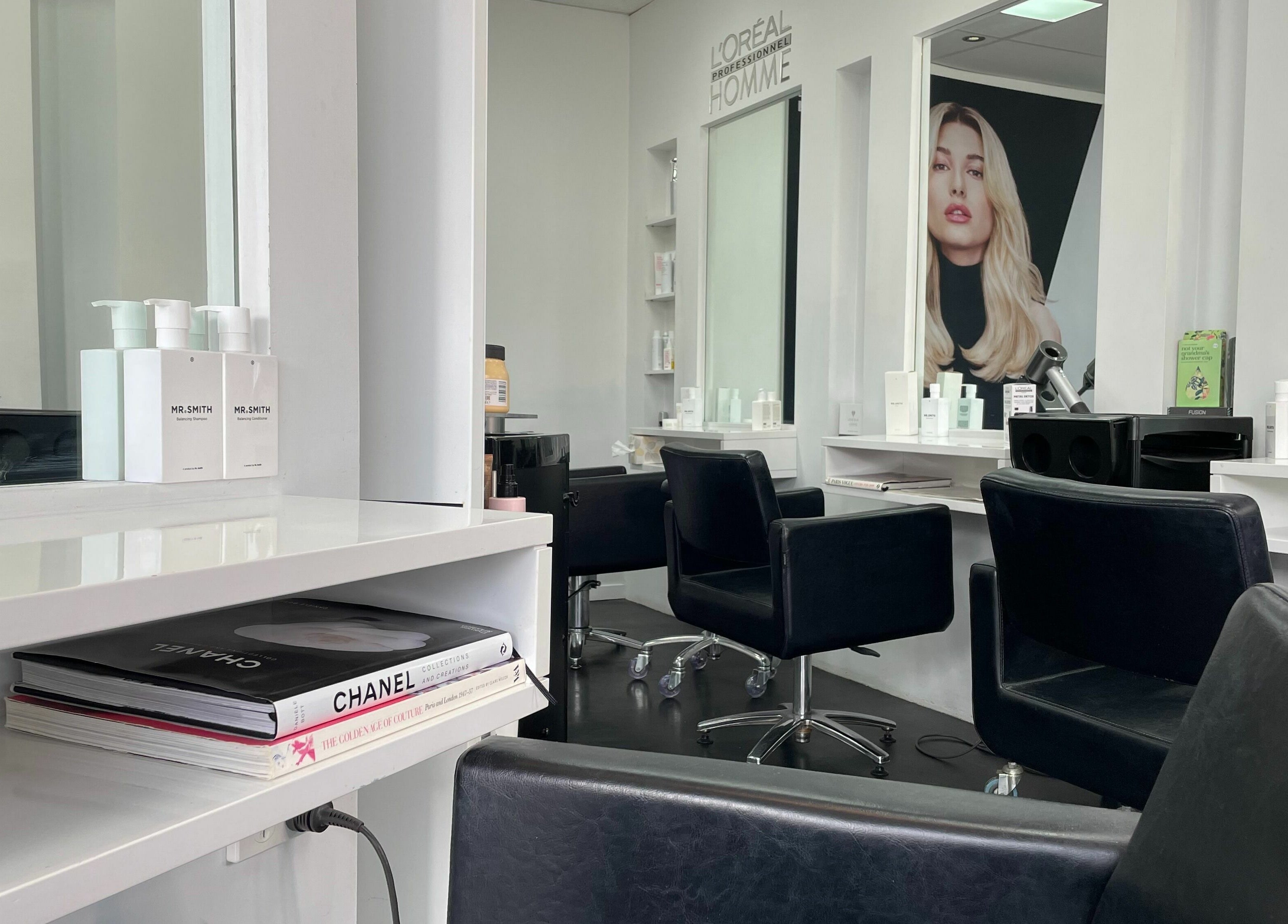 Modern salon interior at Suite Three, Buderim, Queensland, AU, featuring stylish black chairs and elegant decor.