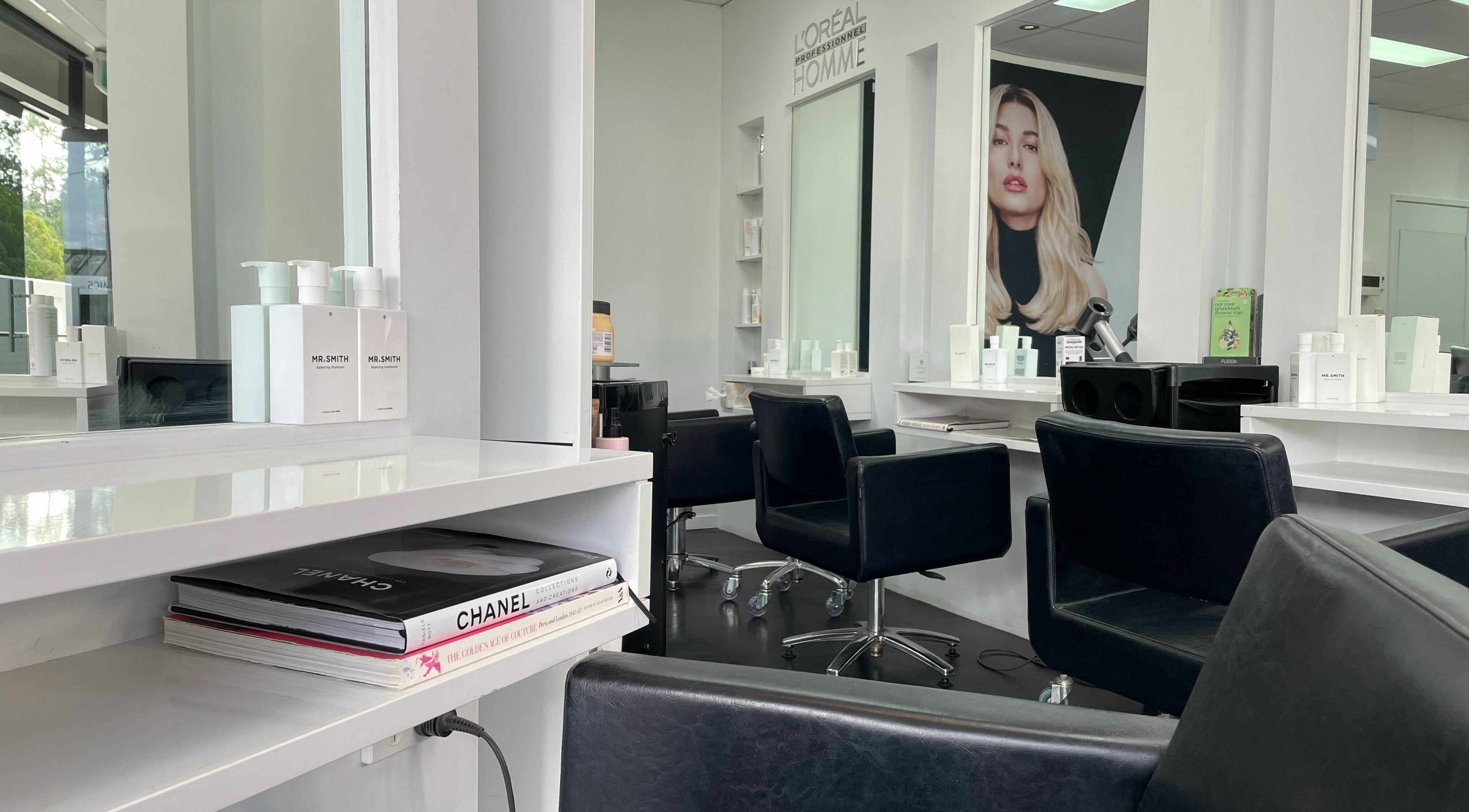 Modern salon interior at Suite Three, Buderim, Queensland, AU, featuring stylish black chairs and elegant decor.