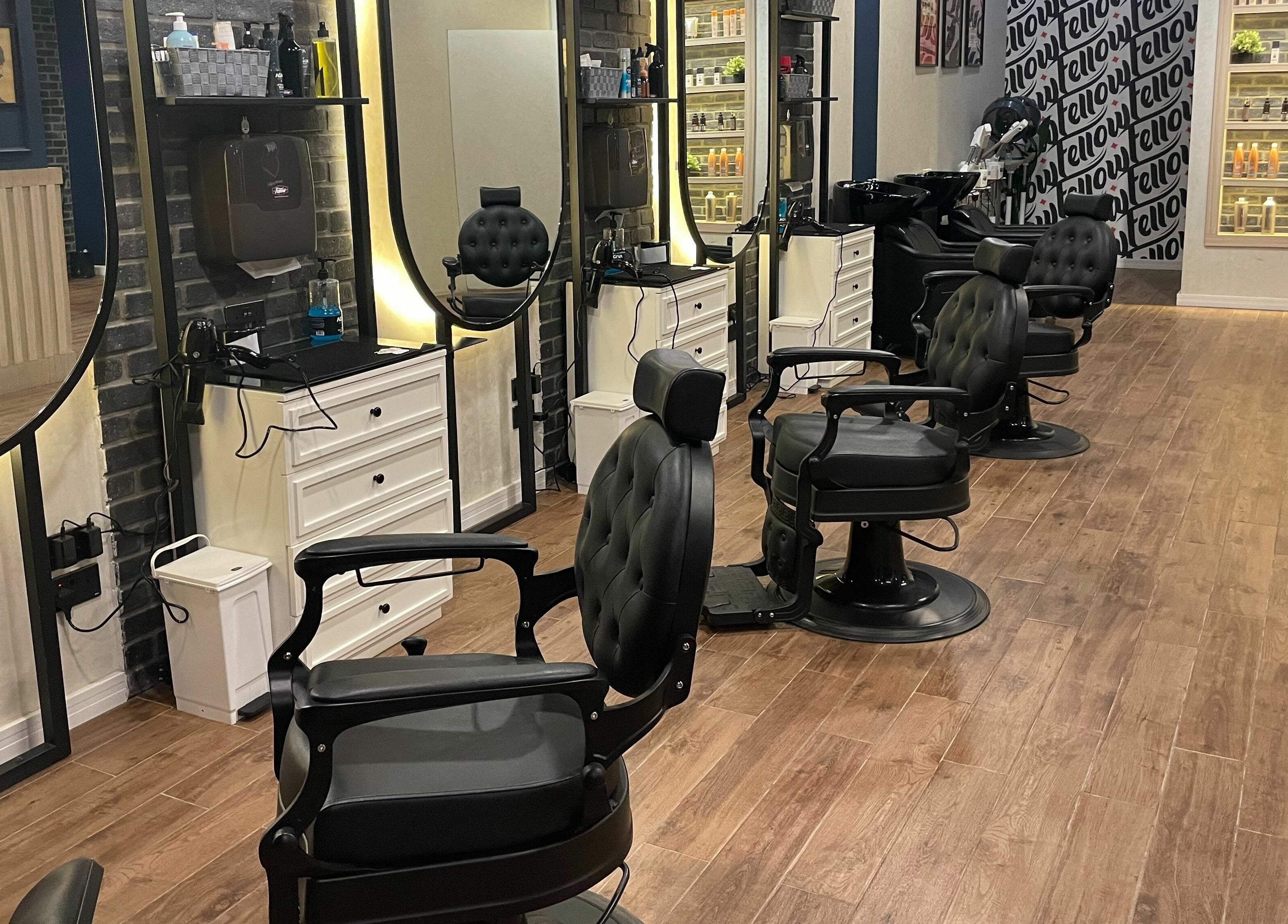 Interior of Fellow | حلاق فيلو in Riyadh, featuring modern barber chairs and illuminated mirrors.