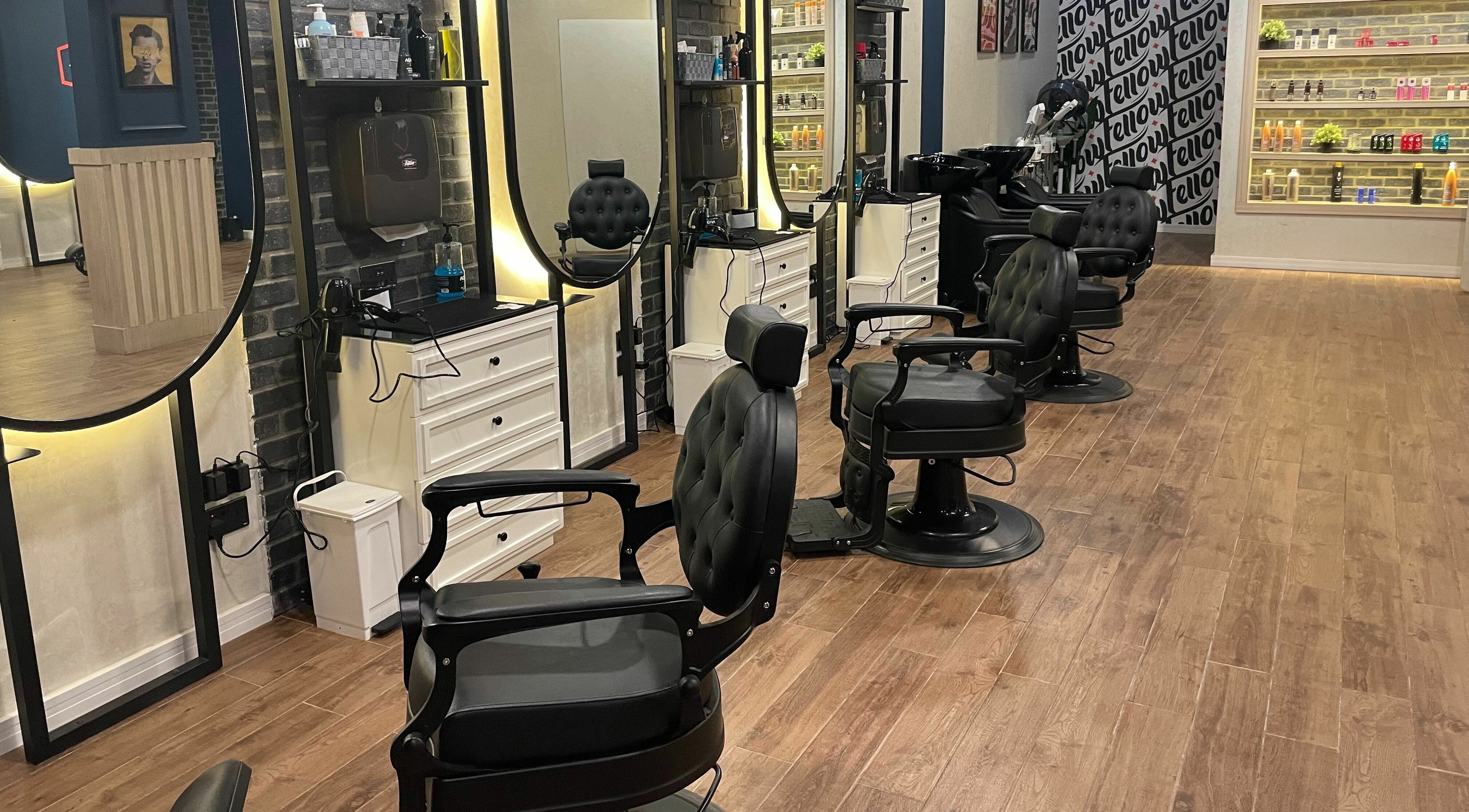 Interior of Fellow | حلاق فيلو in Riyadh, featuring modern barber chairs and illuminated mirrors.