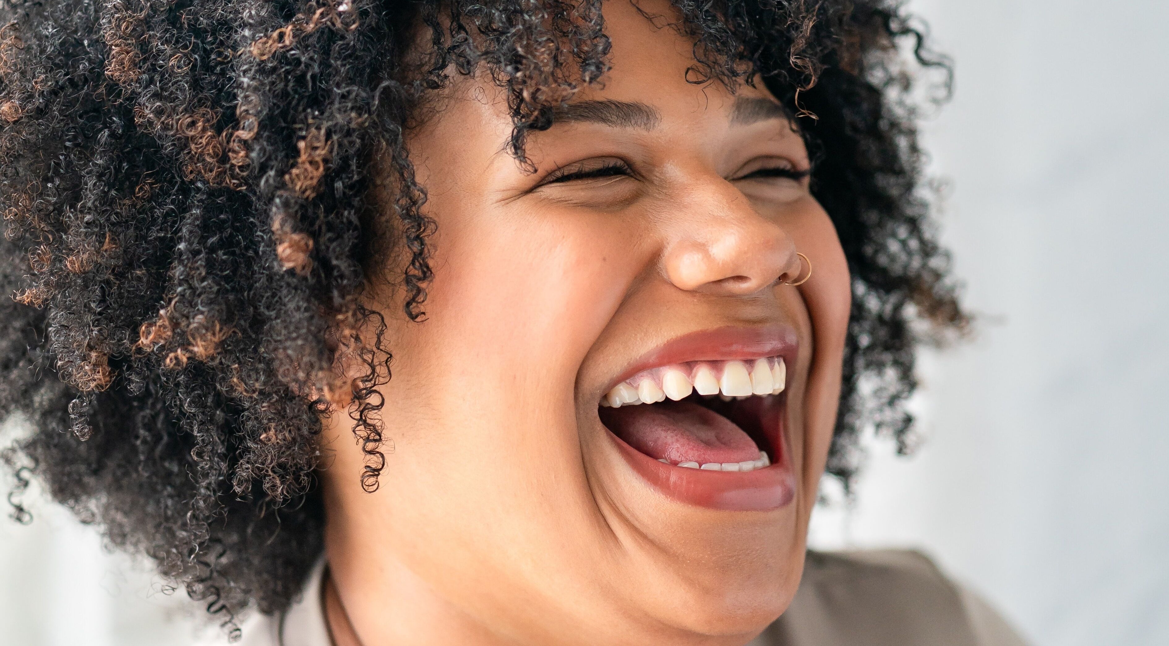 A person with curly hair joyfully laughing at Serena Giscombe & Co, Sheffield, England, GB.