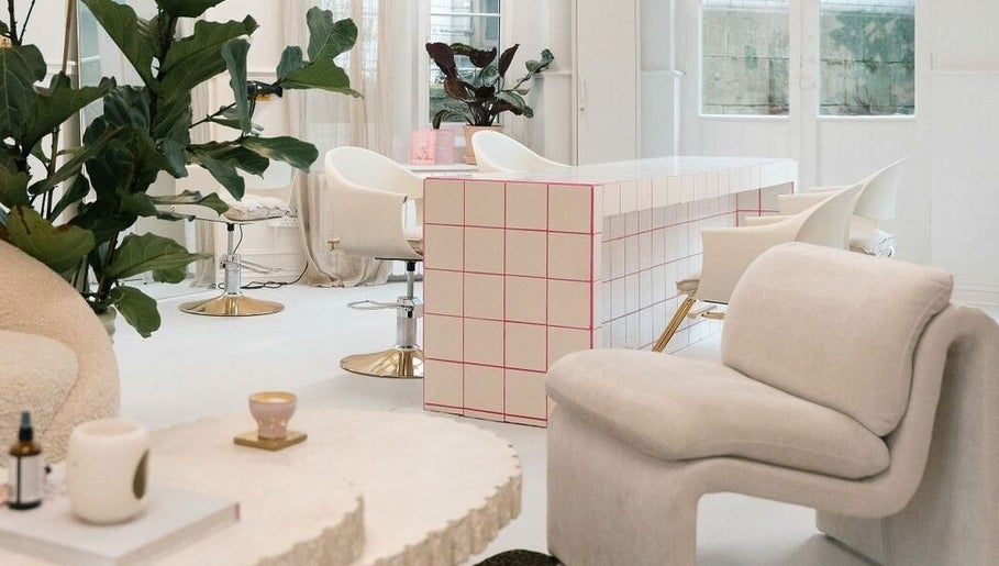 Modern salon interior at STYLD in Bath, England, GB featuring chic seating and lush plants.