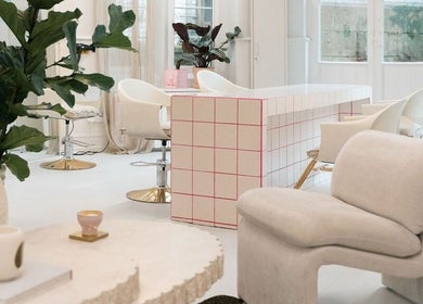 Modern salon interior at STYLD in Bath, England, GB featuring chic seating and lush plants.