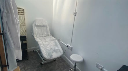 Effortless beauty treatment room in London, England, GB, featuring a comfortable treatment chair and stool.