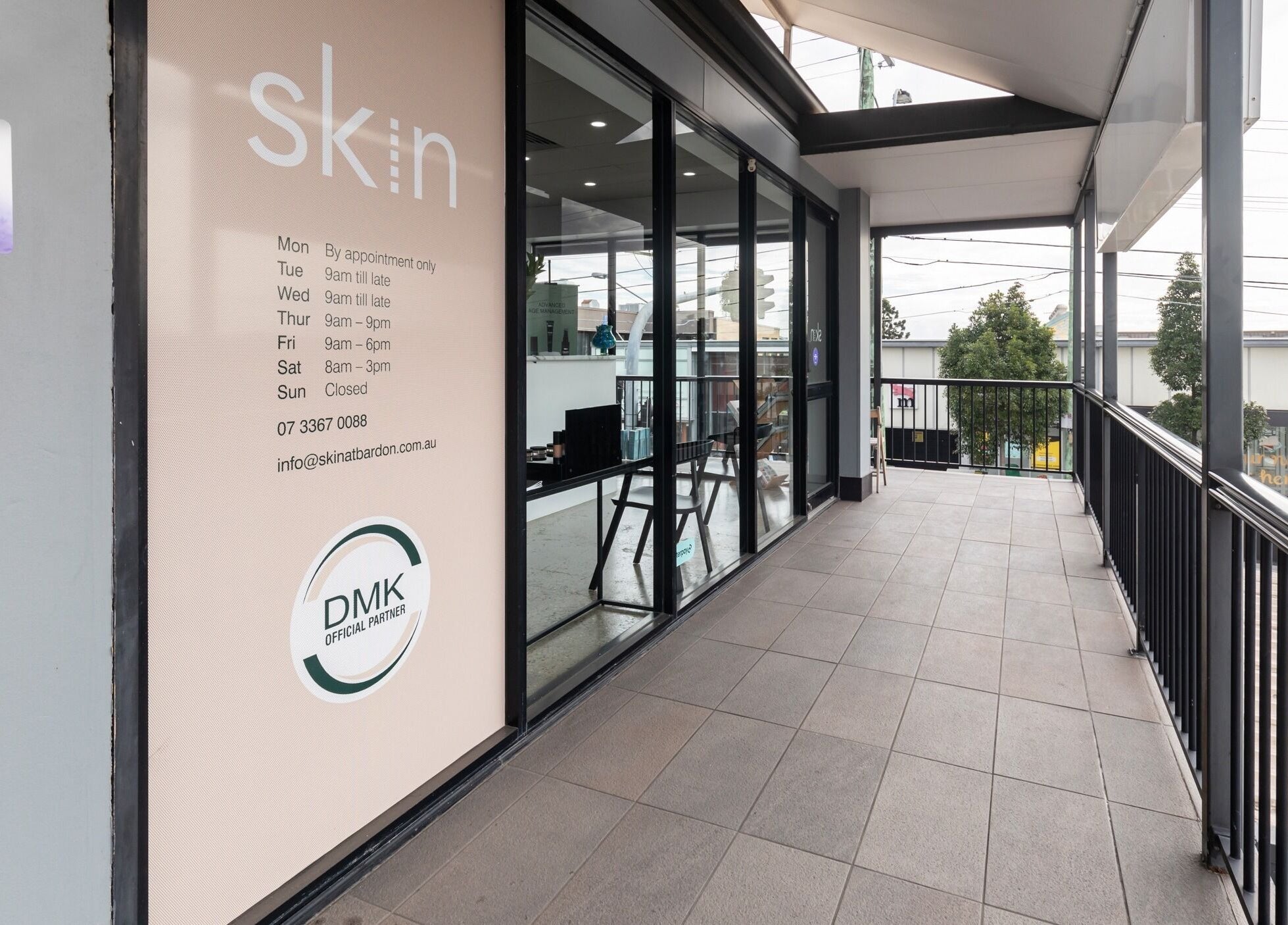 Entrance to Skin at Bardon, Bardon, Queensland, AU, showcasing modern glass facade and appointment details.
